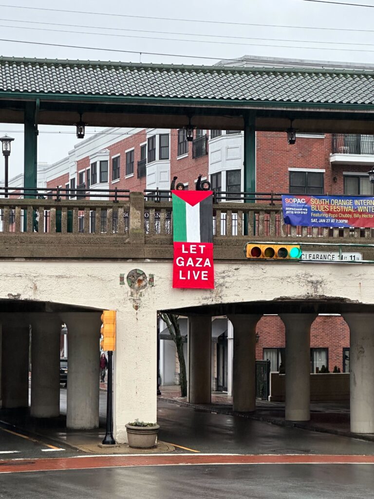 Activists hold a banner reading "Let Gaza Live" above South Orange Avenue in South Orange, NJ
